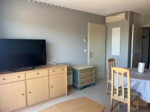a living room with a television and a bed and a table at Résidence la Marquise in Trébas