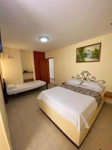 a bedroom with a large white bed in a room at Hotel Terranova SM in Santa Marta +6 photos