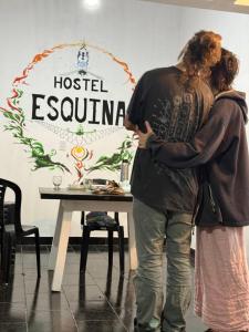 a man and a woman standing in front of a table at Esquina Hostel in Esquina +2 photos