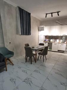 a living room with a table and chairs and a kitchen at Hillside House Overlooking Batumi in Charnali
