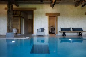 a swimming pool with a chair and a bench in a room at Domaine de Locguénolé & Spa - Relais & Chateaux in Kervignac