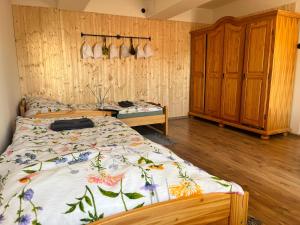 a bedroom with a bed and a wooden wall at Statek Soví Dvůr in Rabyně