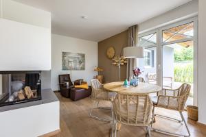 a living room with a table and chairs and a fireplace at Freischwimmer in Wieck