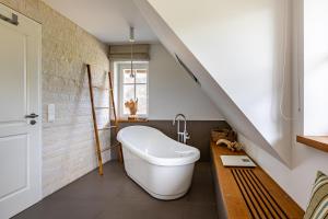 a bathroom with a white bath tub and a staircase at Freischwimmer in Wieck +34 photos