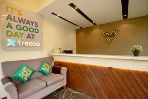 a waiting room with a couch in front of a counter at Treebo Five Elements with Swimming Pool in Lonavala