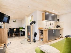 a room with a kitchen and a living room with a fireplace at Waldidyll - Ruhe mitten im Wald in Dahlen