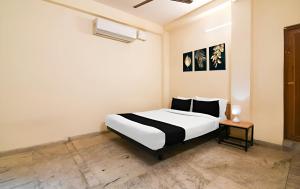 a bedroom with a large white bed and a table at Super Hotel O Profulla Devi Guest House in Jojera +17 photos