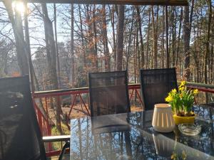 a glass table with chairs and flowers on a porch at Waldidyll - Ruhe mitten im Wald in Dahlen