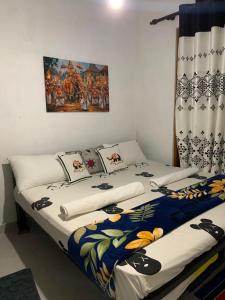 a bedroom with two beds and a painting on the wall at Gagana Vila 01 in Kandy