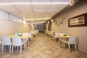 a dining room with tables and white chairs at Treebo Five Elements with Swimming Pool in Lonavala