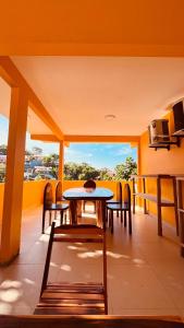a patio with a table and chairs on a balcony at Uma Janela Para o Sol in Morro de São Paulo