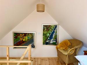 a room with two paintings on the wall and a chair at Agroturystyka Evita in Jabłeczna