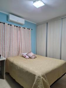 a bedroom with a bed with a pillow on it at orquídea in Paulínia