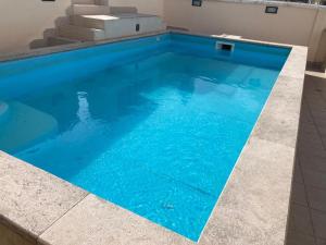 a swimming pool with blue water in a building at Palazzo Sottile Meninni - CLASSIC ROOMS EXPERIENCE in Gravina in Puglia