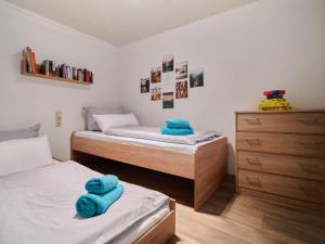 two beds in a bedroom with blue towels on them at Waldidyll - Ruhe mitten im Wald in Dahlen