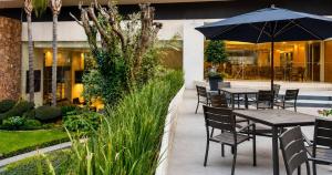 a patio with tables and chairs and an umbrella at Panorama in San Luis Potosí
