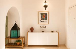 a living room with a white cabinet and a lamp at Maison de la Mer in Ḩammām al Ghazzāz