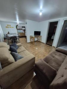 a living room with two couches and a table at Pousada Maria in Maravilha