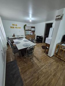 a kitchen with a table and chairs in a room at Pousada Maria in Maravilha