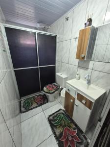 a bathroom with a shower and a toilet and a sink at Pousada Maria in Maravilha