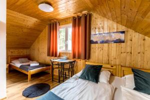 a bedroom with two beds and a table in a room at Fakanalas Fogadó in Pásztó