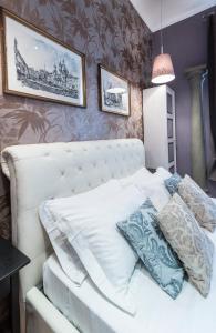 a bedroom with a white bed with pillows on it at Vite Suites Guest House in Rome