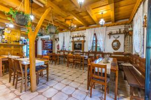 a restaurant with wooden tables and wooden chairs at Fakanalas Fogadó in Pásztó