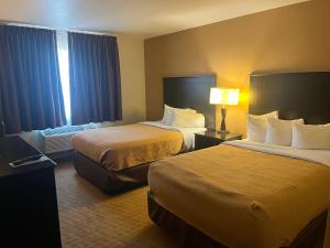 a hotel room with two beds and a window at Chieftain Conference Center in Carrington