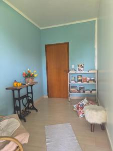 a living room with a door and a table and a table at orquídea in Paulínia +1 photo