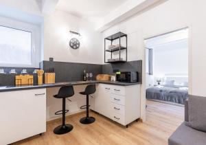 a kitchen with a counter and stools in a room at Calm Center Modern Apartment in Staré Mesto