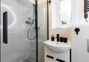 a white bathroom with a sink and a shower at Calm Center Modern Apartment in Staré Mesto +16 photos