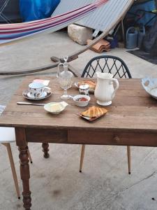a wooden table with plates of food on it at la MORINNIERRE in Saint-Jean-de-Beugné