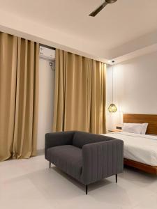 a bedroom with a bed and a couch in it at Coral by Ivory Hotels in Mombasa +25 photos