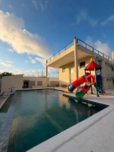 a swimming pool with a playground next to a building at Coral by Ivory Hotels in Mombasa