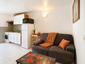 a living room with a couch and a kitchen at Le St Joseph in Vérin