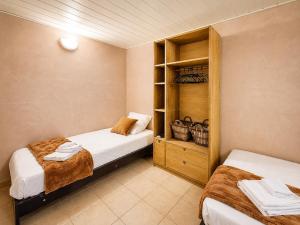 a bedroom with two beds and a cabinet with towels at Le St Joseph in Vérin