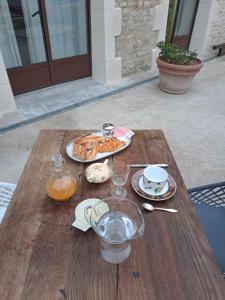 a wooden table with a plate of food on it at la MORINNIERRE in Saint-Jean-de-Beugné