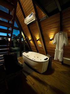 a bathroom with a sink and a bath tub at Chalés Villa Alecrim COM HIDROMASSAGEM E AR CONDICIONADO in Campos do Jordão