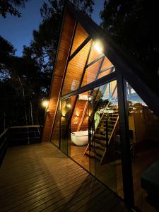 a house with glass doors and a tub on a deck at Chalés Villa Alecrim COM HIDROMASSAGEM E AR CONDICIONADO in Campos do Jordão +77 photos