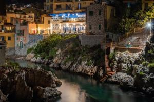 a river in a town at night at La perla del mare in Santa Flavia
