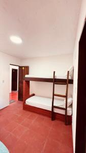 a room with a bunk bed with a chair in it at Uma Janela Para o Sol in Morro de São Paulo