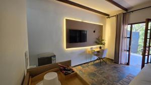 a living room with a television and a room with a chair at Mvubu Falls Lodge in Lobamba +16 photos