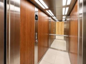 a walkway with wood and stainless steel doors and a corridor at Augustowskie Apartamenty Blisko Jezior i Lasów oraz Bezpłatny parking in Augustów