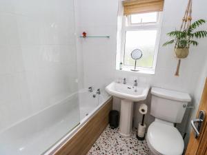a bathroom with a toilet and a sink and a tub at Snowdrop Cottage in Keighley