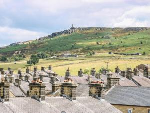 a group of houses with a hill in the background at Snowdrop Cottage in Keighley