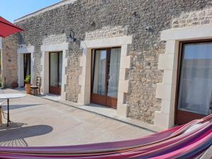 a hammock in front of a brick building at la MORINNIERRE in Saint-Jean-de-Beugné +8 photos