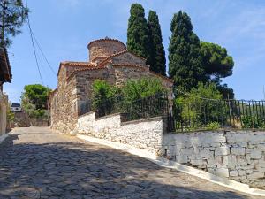 an old stone building with a fence and trees at Seaside olive grove in Pyrgi Thermis