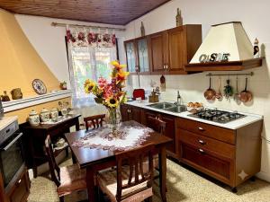 a kitchen with a table with a vase of flowers on it at Civico 31 in Terralba