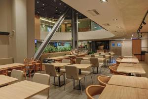 a restaurant with tables and chairs and people sitting at tables at Ibis Maringa in Maringá
