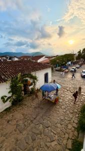 a group of people standing under a blue umbrella at Pousada Café e Prosa Centro Histórico Paraty in Paraty